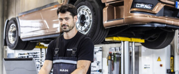 MAN-Lkw aufgebockt mit Arbeiter im Vordergrund