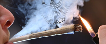 Mann raucht Cannabis, deutscher Adler hustet im Rauch
