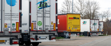 LKW stehen dicht an dicht auf einem Autobahnparkplatz. Hohe Auslastung und fehlende Stellplätze erschweren Ruhezeiten für Fahrer und zeigen Probleme in Infrastruktur, Logistik und Güterverkehr