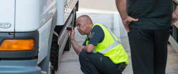 Ein Polizeibeamter überprüft einen Lkw auf einem Rastplatz an der Autobahn