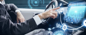 Mann am Steuer eines Pkw klickt auf dem Boardcomputer