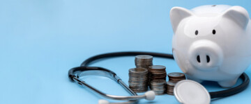 Betriebliche Krankenversicherung, Sparschwein mit GEldmünzen und Stetoskop