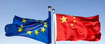 Flaggen von der EU und China flattern in entgegengesetzte Richtungen