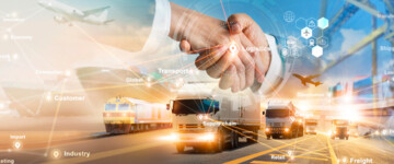  Handschlag von zwei Geschäftspartnern vor einer Grafik einer logistischen globalen Netzwerkverteilung bezüglich Transport-Geschäfte