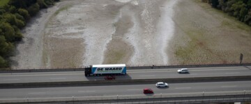 Lkw fährt über eine Brücke über den von Niedrigwasser betroffenen Rhein bei Bendorf