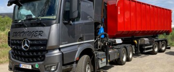 Die Kombination für den Hackschnitzeltransport besteht aus einer dreiachsigen Zugmaschine und einem Auflieger mit Hakenlift sowie zwei elektrohydraulisch gelenkten Achsen
