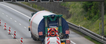 Schwertransporter mit Teilen einer Windkraftanlage fährt über die Autobahn