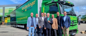 Stehen vor einem Lkw von Karldischinger Logistikdienstleister: Oliver Berger, Manager Transport Network bei Daimler Truck, Jürgen Distl, Head of Operations Mercedes-Benz Trucks, Karlkristian Dischinger, Geschäftsführer bei Karldischinger Logistikdienstleister, Volker Speck, COO Wirtschaftsraum Südbaden bei der Kestenholz Gruppe, Karlhubert Dischinger, Gesellschafter bei karldischinger logistikdienstleister, Stephan Kestenholz, Präsident des Verwaltungsrats bei der Kestenholz Automotive Holding, Christian Wilz, Vorsitzender der Geschäftsleitung Mercedes-Benz Trucks & FUSO Deutschland, und Thomas Kestenholz, CEO der Kestenholz Gruppe. Die Kestenholz Gruppe ist Partner und Händler von Mercedes-Benz Trucks.