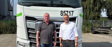 LIT-Vorstandsmitglied Ingo Schreiber (r.) und Michael Henschel, Geschäftsführer der Kombi Fracht GmbH, stehen vor einem neuen DAF-Lkw im Kombifracht-Design, der im Rahmen der Übernahme angeschafft wurde