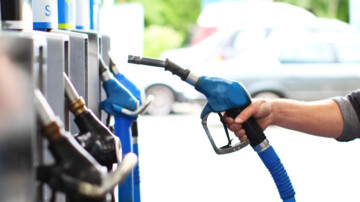 Person nimmt Zapfhahn aus der Tanksäule