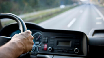 Lkw-Fahrer hinterm Steuer, die Straße vor der Windschutzscheibe