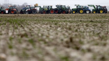 Teilnehmer der Bauernproteste fahren mit ihren Traktoren im Kors