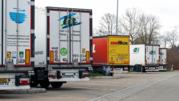 LKW stehen dicht an dicht auf einem Autobahnparkplatz. Hohe Auslastung und fehlende Stellplätze erschweren Ruhezeiten für Fahrer und zeigen Probleme in Infrastruktur, Logistik und Güterverkehr