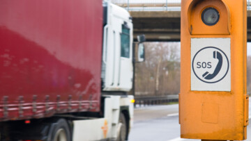 Autobahn-Notrufsäule mit Lkw im Hintergrund