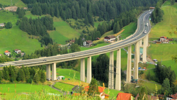 Die Brennerautobahn 12 schlängelt sich als Luegbrücke durch das saftige Tal