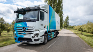 Ein Mercedes-Benz eActros 400 fährt als 6x2-Chassis mit Kofferaufbau durch die Landschaft
