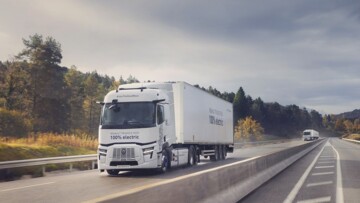 Der neue Renault E-Tech T 780 rollt als weiß lackierte Sattelzugmaschine über die Autobahn. Das Fahrzeug zieht einen weiß lackierten Kühlkoffer