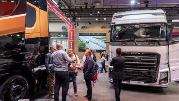 Pressetag auf der IAA Transportation 2024: Besucher stehen in der Messehalle vor zwei Lkw und diskutieren