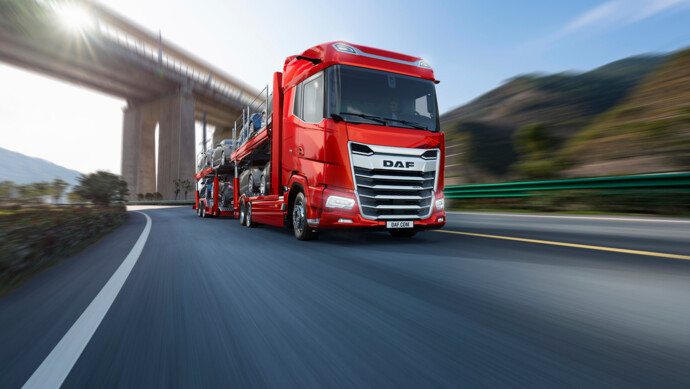 Ein DAF mit XG+-Fahrerhaus und Autotransportaufbau fährt in roter Lackierung über die Autobahn