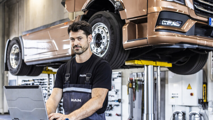 MAN-Lkw aufgebockt mit Arbeiter im Vordergrund