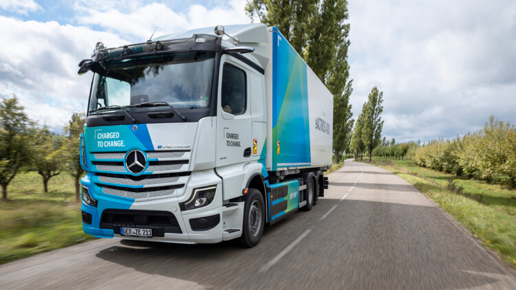 Ein Mercedes-Benz eActros 400 fährt als 6x2-Chassis mit Kofferaufbau durch die Landschaft
