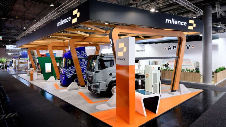 Stand von Milence auf der IAA Transportation 2024: Mehre Lkw stehen an Ladesäulen auf dem Stand