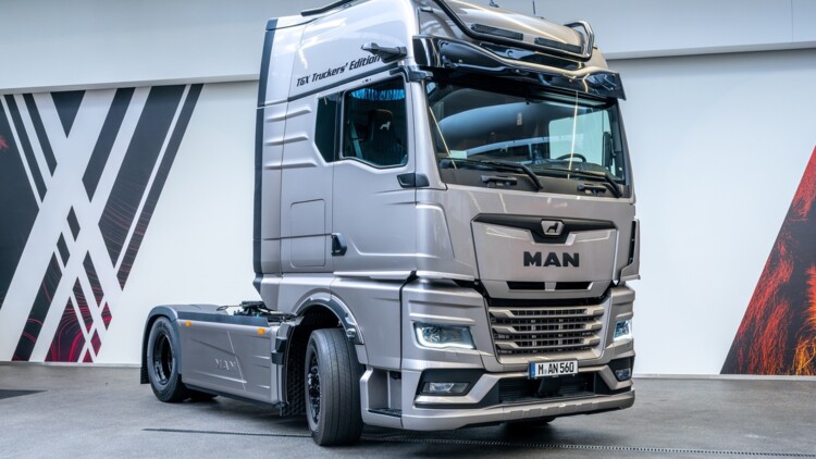 Der MAN TGX Truckers-Edition in der seitlichen Frontansicht. Die metallic-grau lackierte Zugmaschine steht in der Auslieferungshalle des Truck-Forums von MAN Truck & Bus im Werk München 