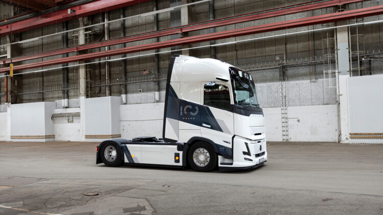 Das neue Sondermodell von Volvo Trucks steht in einer Halle. Die Solo-Sattelzugmaschine ist von vorne rechts fotografiert und präsentiert sich in weißer Lackierung mir schwarzen 100-Jahre-Jubiläums-Schriftzügen  